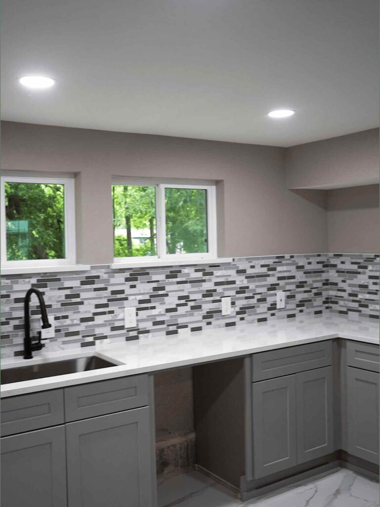 Modern bathroom corner highlighting a white marble-look tub surround, tiled walls, and a recessed storage niche.