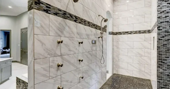 Marble tile shower with multiple body jets and mosaic accent by Iconic Custom Home Builders Houston