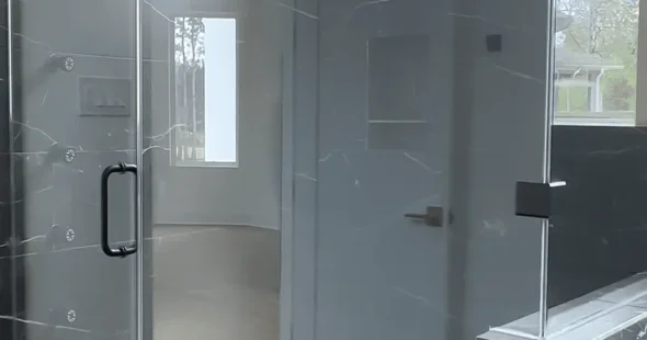 Frameless glass shower with marble tile walls and natural light, Iconic Custom Home Builders Spring TX